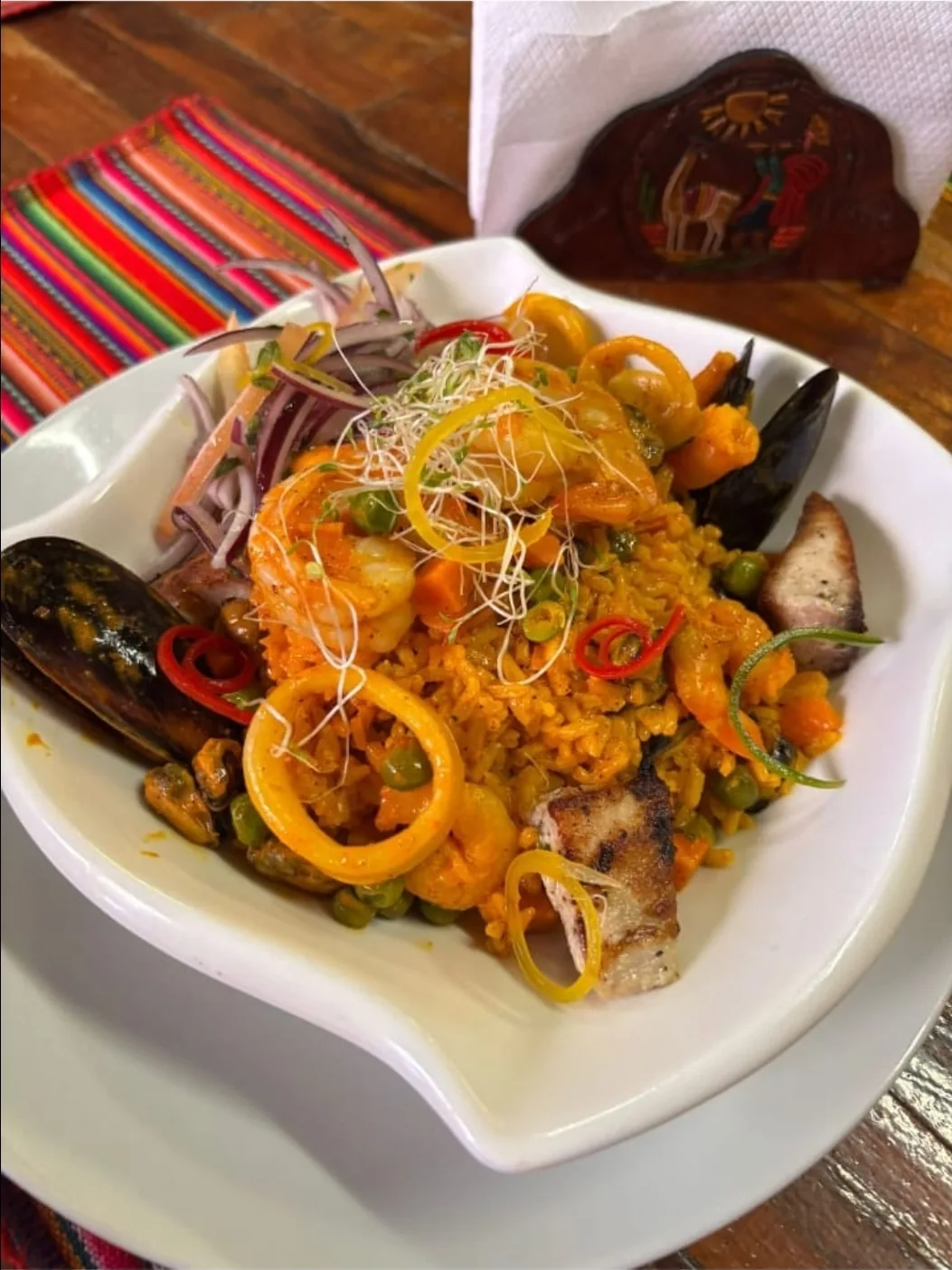 Arroz con mariscos at Peruvian Latinos: saffron-hued rice with shrimp, mussels, calamari rings and octopus, topped with red onion salsa